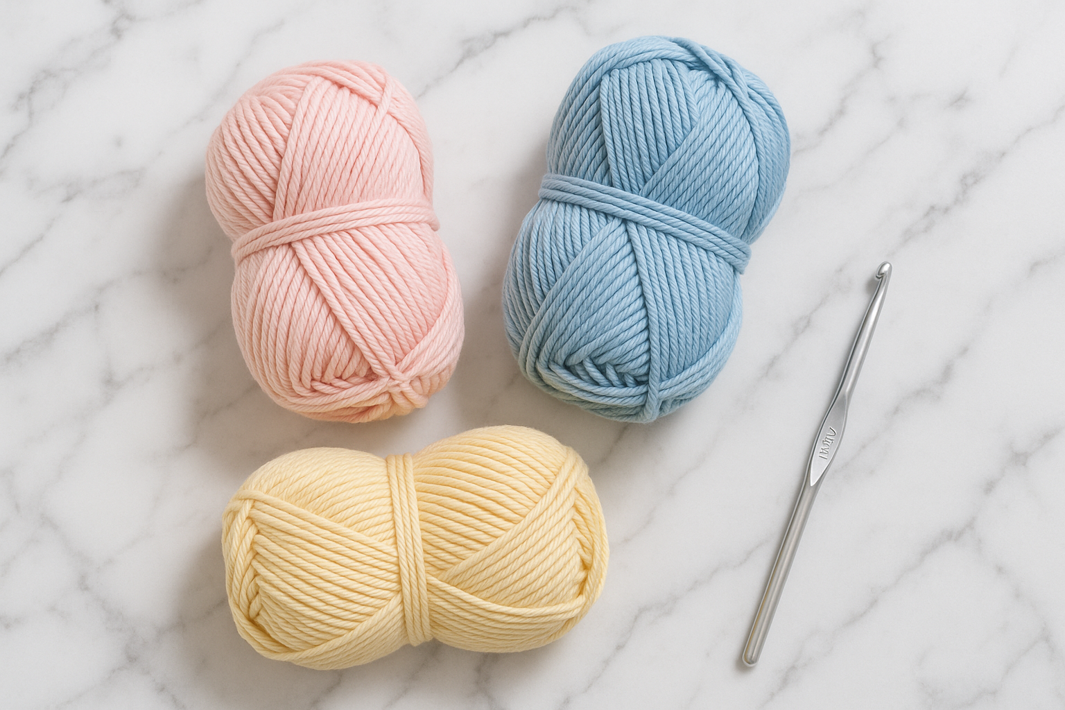 3 skeins of cotton DK yarn without a label in light pink, light blue, and yellow, with a 4mm crochet hook on a marble background
